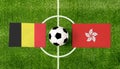 Top view ball with Belgium vs. Hong Kong flags match on green football field Royalty Free Stock Photo