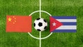 Top view ball with China vs. Cuba flags match on green soccer field
