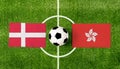 Top view ball with Denmark vs. Hong Kong flags match on green football field Royalty Free Stock Photo