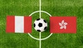 Top view ball with Peru vs. Hong Kong flags match on green football field Royalty Free Stock Photo