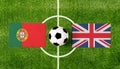 Top view ball with Portugal vs. United Kingdom flags match on green football field