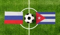 Top view ball with Russia vs. Cuba flags match on green soccer field