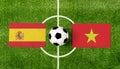 Top view ball with Spain vs. Vietnam flags match on green soccer field