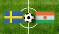 Top view ball with Sweden vs. Niger flags match on green football field