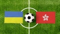 Top view ball with Ukraine vs. Hong Kong flags match on green football field Royalty Free Stock Photo