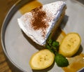 Top view of Banana Banoffee pie with bananas slice and peppermint leaves on gray ceramic plate