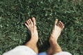 Top view bare male feet on green grass, connecting with nature