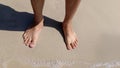 Top view of bare men's feet with approaching a man standing on the san Royalty Free Stock Photo