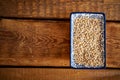 Top view of barley porridge in a white ceramic bowl on an wooden table Royalty Free Stock Photo