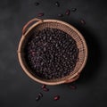 Top view of a basket full of black beans on a dark background