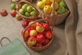 Top view of baskets with apples of different varieties, standing on burlap