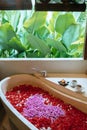 Top view of bath tub with heart shaped flower petals. Two cups of herbal tea on edge. Spa,organic and skin care, beauty treatment Royalty Free Stock Photo