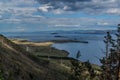 top view of the bay of lake Baikal with islands, peninsulas, clouds, mountains and hills with green trees