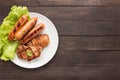 Top view BBQ Grilled meat, sausages and vegetables on dish on wooden background. Copy space for your text Royalty Free Stock Photo