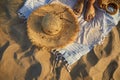 Top view of beach accessories. Straw hat, bag, flip flops on sand at beach. Royalty Free Stock Photo