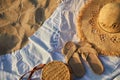 Top view of beach accessories. Straw hat, bag, flip flops on sand at beach. Royalty Free Stock Photo