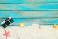 top view of beach sand with retro camera, starfish and shells on blue wooden background. Royalty Free Stock Photo