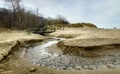 View of a beach washed by sea water, with rocks. Wet sand is drawings rivers and stones under a dramatic cloudy sky Royalty Free Stock Photo