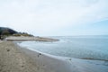 View of a beach washed by sea water, with rocks. Wet sand is drawings rivers and stones under a dramatic cloudy sky Royalty Free Stock Photo