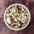 Top view of 13 bean soup ingredients in a white bowl on a maroon table Royalty Free Stock Photo