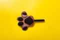bears paw shape chocolate flavor popsicle starts melting on yellow background
