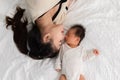 Top view of Beautiful Attractive Asian mom lying on bed kissing on baby sweet and lovely.Happy mother and infant baby looking