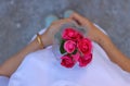 Top view of a beautiful bouquet of red roses is held on hand of middle aged woman with white shirt background. Love and romance Va
