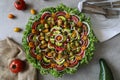 Top view of beautiful Mandala like fresh tomato, avocado, olives, lettuce and onion salad garnished with spring onion & nigella se