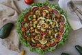 Top view of beautiful Mandala like fresh tomato, avocado, olives, lettuce and onion salad garnished with spring onion & nigella se Royalty Free Stock Photo