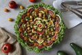 Top view of beautiful Mandala like fresh tomato, avocado, olives, lettuce and onion salad garnished with spring onion & nigella se