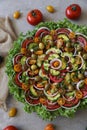 Top view of beautiful Mandala like fresh tomato, avocado, olives, lettuce and onion salad garnished with spring onion & nigella se