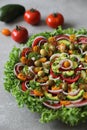 Top view of beautiful Mandala like fresh tomato, avocado, olives, lettuce and onion salad garnished with spring onion & nigella se