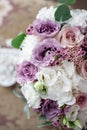 Top view on beautiful modern and stylish wedding bouquet of white, purple roses and eucalyptus greenery. Royalty Free Stock Photo