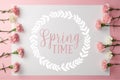 Top view of beautiful pink and white carnation flowers and card with springtime lettering in round frame