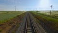 Top view of beautiful railway on background of green field. Shot. Wind farm near beautiful railway in green field