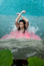 Top view of a beautiful sexy woman with vitiligo disease under the pink illuminated splashing water of the waterfall in the Spa Royalty Free Stock Photo