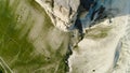 Top view of beautiful white rock with green grass on background of blue sky. Shot. Panorama of white cliff with green