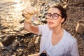 Top view of beautiful woman ecologist wearing rubber gloves and eyeglasses examines test flask of water. Concept of