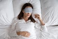 Top view beautiful woman wearing sleeping mask lying in bed Royalty Free Stock Photo
