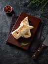 Top view of a beautiful wooden cutting board with shawarma. On a dark marble background. Red, black pepper, knife and rosemary Royalty Free Stock Photo