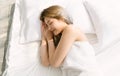 Top view of beautiful young Asian woman smiling while sleeping in her bed and relaxing in the morning at home. Lady enjoying sweet Royalty Free Stock Photo