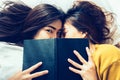 Top view of beautiful young asian women lesbian happy couple kiss and smiling while lying together in bed under book at home. Royalty Free Stock Photo