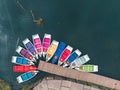 Top view of beautifully arranged multi coloured boats on a blue lake. Drone perspective of rainbow boats on water