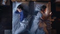 Top View Bedroom Apartment: Young Woman Uses Smartphone in Bed at Night When Her Male Partner Trying