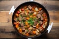 top view of beef stew in cast iron pot, steam visible