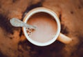 Top view of a beige mug with warm delicious fragrant cocoa with milk. Nice breakfast. Coffee with milk in the morning