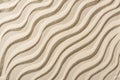 Top view of beige sandy backdrop with smooth waves.