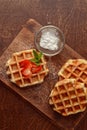 Top view belgian waffles with strawberries on cutting board