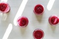 Top view of berry smoothies in glass jars on white wooden table with sunlight patterns Royalty Free Stock Photo