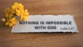 Top view of Bible verse Nothing is impossible with God. Yellow flower and wooden background. Royalty Free Stock Photo